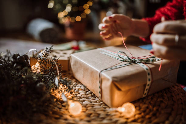 Woman Wrapping Christmas Gifts Young Woman Wrapping Christmas Gifts In Living Room wrapping paper stock pictures, royalty-free photos & images