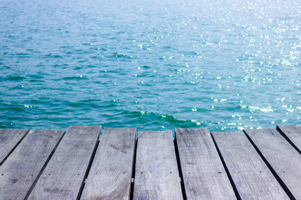 istock wooden table top with blue sea background. 1083536072