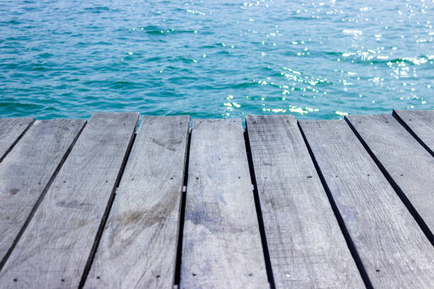 istock wooden table top with blue sea background. 1083536074