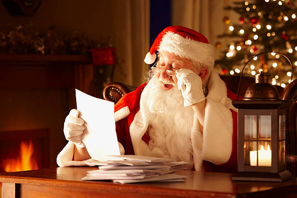 Jolly Father Christmas Reading letters from children Portrait of Father Christmas Reading letters from children in his grotto cape garment photos stock pictures, royalty-free photos & images