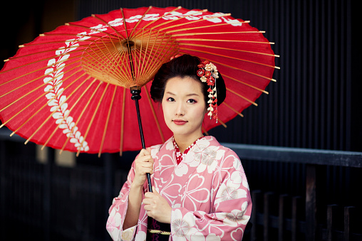 A beautiful Japanese woman dressed in the traditional kimono dress. Kyoto, Japan.
