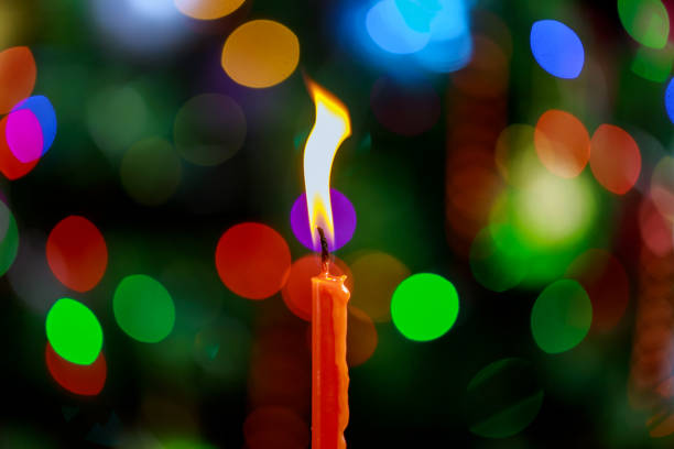 istock One candle flame light at night with bokeh on dark background 1083541480