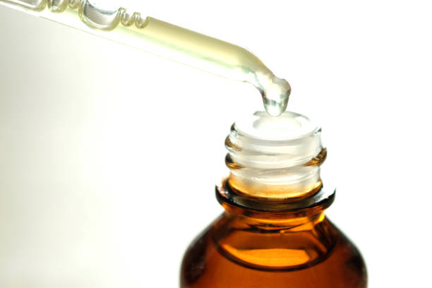 istock Dropping serum collagen moisturizer of face into clear yellow bottle soft light background. Protector skin Treatment facial essence oil, Vitamin C. Beauty and spa Concept. 1083544040