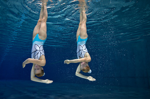 female athlete stands on a springboard, diving competition