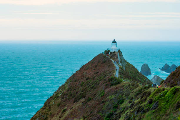 istock Cloudy day at the Nugget Point Lighthouse with doom sky 1083545424