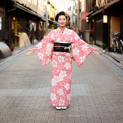 A pretty young Japanese woman wearing a traditional kimono dress standing with open arms in a Japanese street.  Taken on location in Kyoto, Japan.

[url=search/lightbox/9555437] [img]http://richlegg.com/istock/banners/banner_japanwomen.jpg[/img][/url]
[b][url=search/lightbox/9555437]Click HERE for more Beautiful Japanese Women[/url][/b]

[url=search/lightbox/9532452] [img]http://richlegg.com/istock/banners/japan_banner.jpg[/img][/url]
[b][url=search/lightbox/9532452]Click HERE to see more Japanese images[/url][/b]