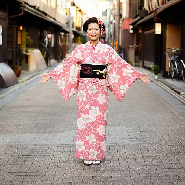 A pretty young Japanese woman wearing a traditional kimono dress standing with open arms in a Japanese street.  Taken on location in Kyoto, Japan.

[url=search/lightbox/9555437] [img]http://richlegg.com/istock/banners/banner_japanwomen.jpg[/img][/url]
[b][url=search/lightbox/9555437]Click HERE for more Beautiful Japanese Women[/url][/b]

[url=search/lightbox/9532452] [img]http://richlegg.com/istock/banners/japan_banner.jpg[/img][/url]
[b][url=search/lightbox/9532452]Click HERE to see more Japanese images[/url][/b]