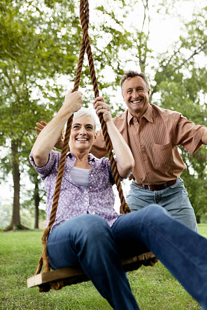 istock Senior Couple Playing on a Park Swing 108355396