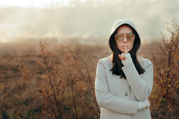 istock Mischievous Woman with Finger on Lips Keeping Secrets 1083556702