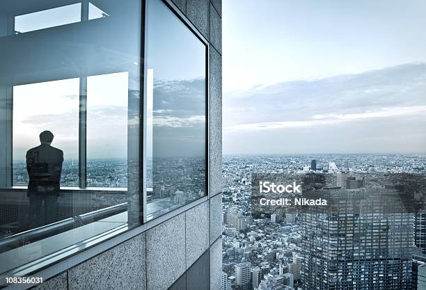 Foto de Homem Em Um Arranhacéu e mais fotos de stock de Edifício Comercial - Edifício Comercial, Janela, Cidade