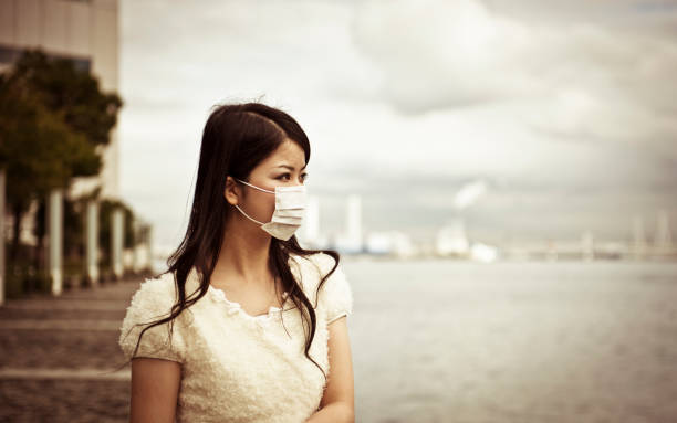 Asian woman wearing face mask with a blurred background stock photo