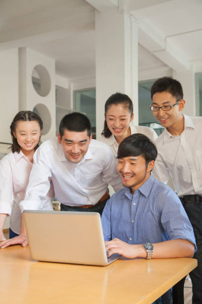 istock Chinese business people using laptop at desk 1083560414