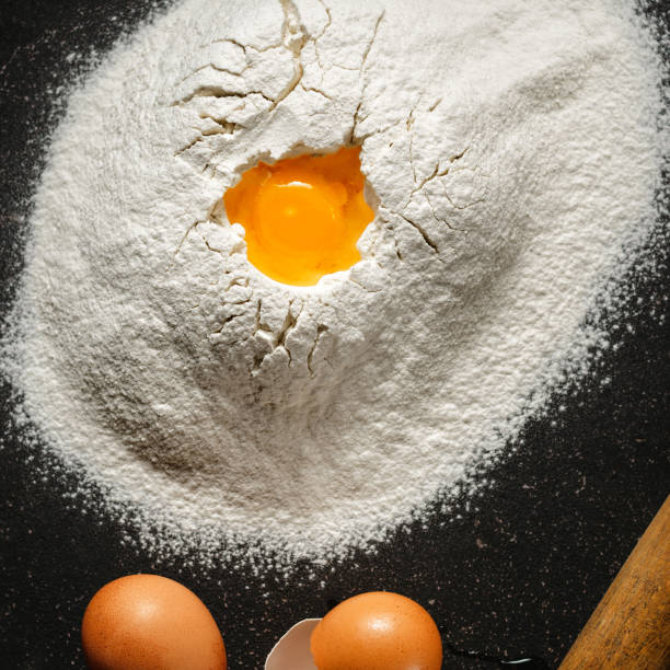 istock Heap flour eggs yolk black background top view 1083565892