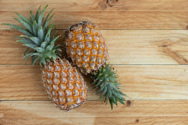 istock Ripe pineapple isolated on a wooden table 1083566050