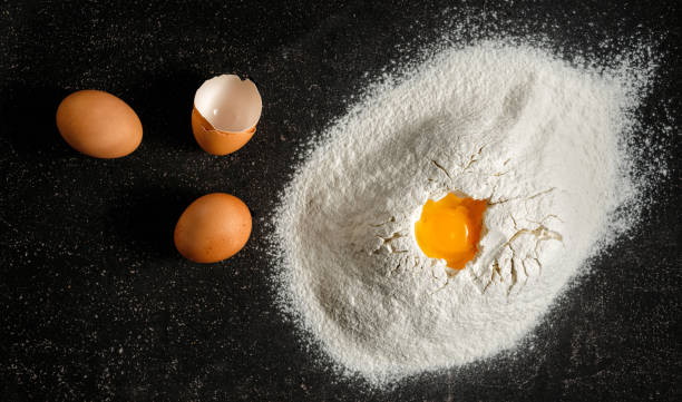 istock Heap flour eggs yolk black background top view 1083566068