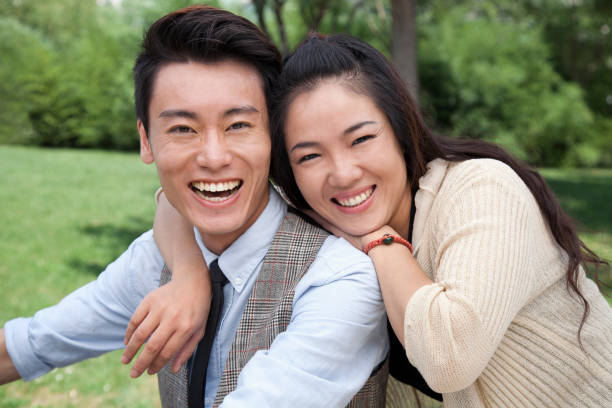 istock Smiling Chinese couple hugging in park 1083571126