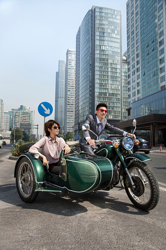 Chinese business people riding motorcycle with sidecar