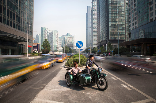 Chinese business people riding motorcycle with sidecar