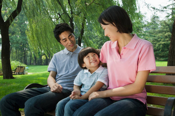 istock Chinese family sitting on park bench 1083574800