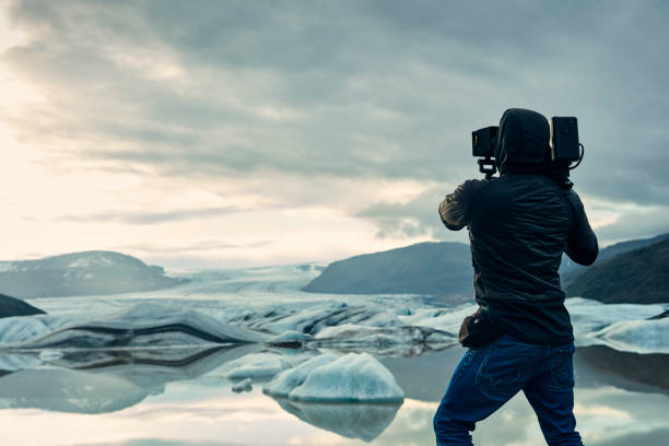 istock Cameraman at glacier lagoon. Sunset 1083589140
