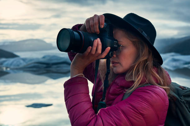 istock Female photographer at glacier lagoon. Sunset 1083590228