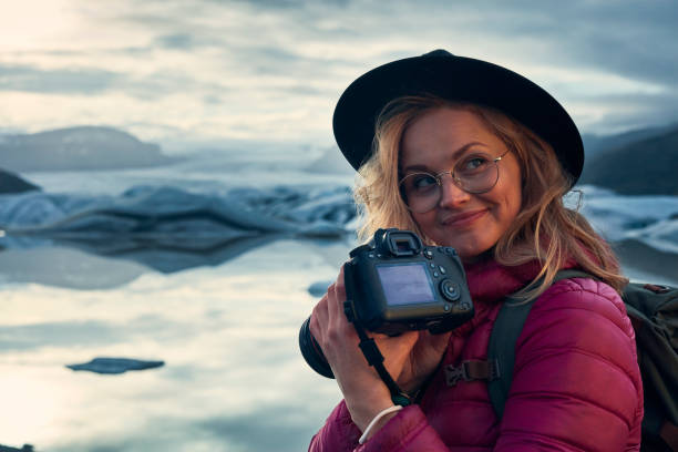 istock Female photographer at glacier lagoon. Sunset 1083590232