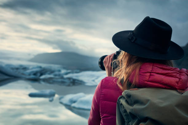 istock Female photographer at glacier lagoon. Sunset 1083590284