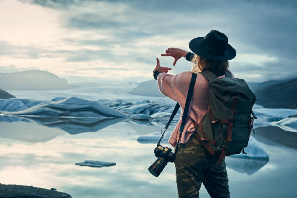 Female photographer at glacier lagoon. Sunset stock photo