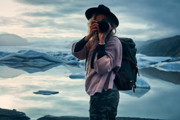 istock Female photographer at glacier lagoon. Sunset 1083590368