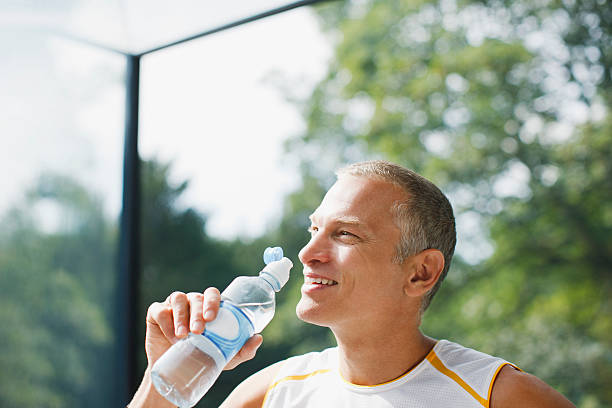 uomo acqua potabile dopo esercizio - drinking men water bottle foto e immagini stock