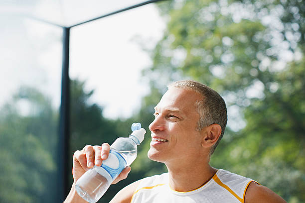 mężczyzna pitnej wody po treningu - water bottle sports and fitness selective focus sport zdjęcia i obrazy z banku zdjęć