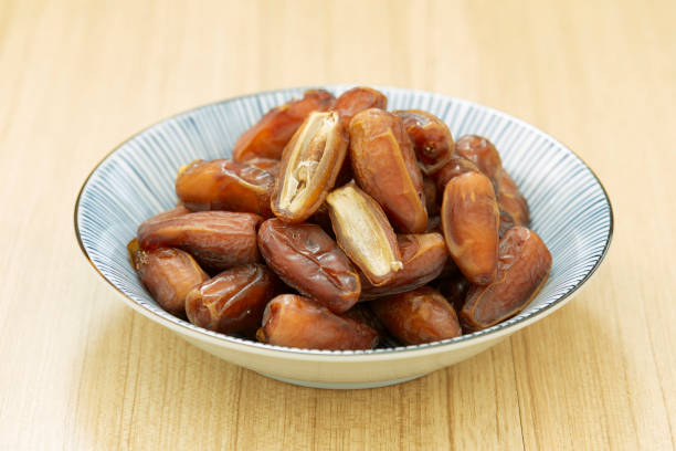 istock Sweet dried dates fruit in a bowl and on the table 1083593188