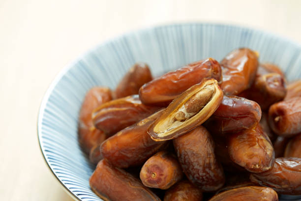 istock Sweet dried dates fruit in a bowl and on the table 1083593206