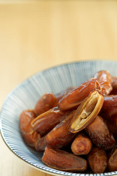 istock Sweet dried dates fruit in a bowl and on the table 1083593224