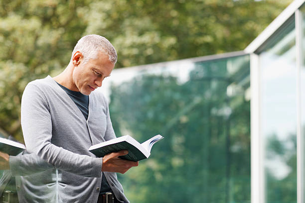 uomo leggendo un libro sul balcone - men reading outdoors book foto e immagini stock