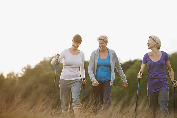 szczęśliwa kobieta razem na zewnątrz pieszych - nordic walking zdjęcia i obrazy z banku zdjęć