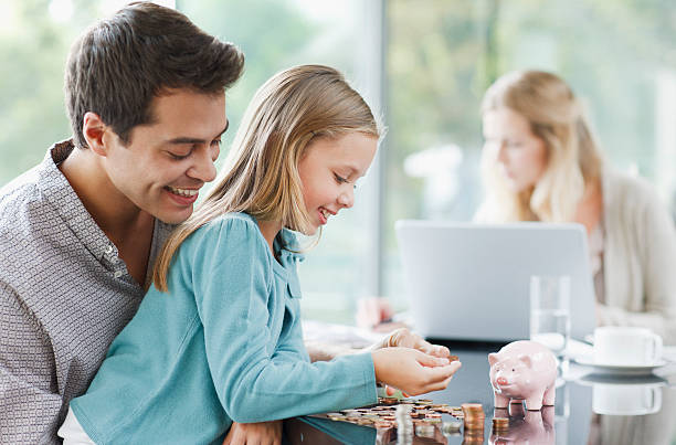 Father watching daughter count coins  piggy bank photos stock pictures, royalty-free photos & images