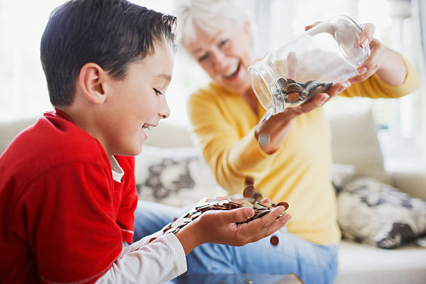 słoik monety z babcia opróżnianie do grandsons ręce - overflowing zdjęcia i obrazy z banku zdjęć