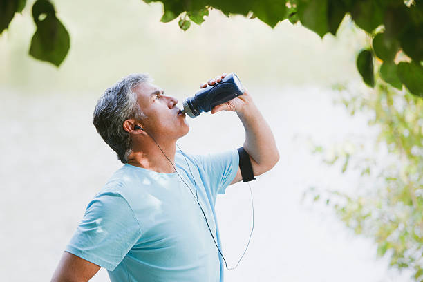 homem beber água depois do exercício - water bottle sports and fitness selective focus sport - fotografias e filmes do acervo