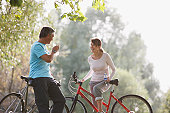 Couple with bicycles drinking water