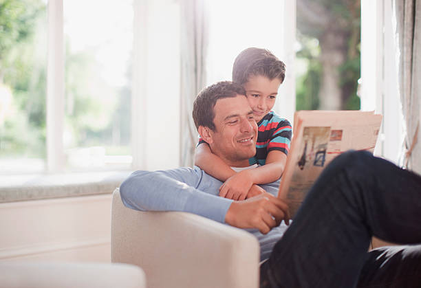 pai e filho a ler jornal juntos - reading newspaper 30s adult imagens e fotografias de stock
