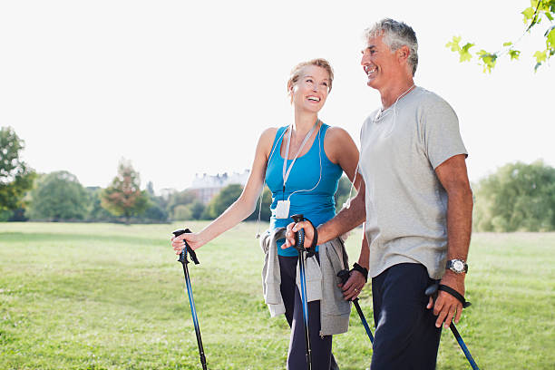 uśmiechnięta para pieszych razem - nordic walking zdjęcia i obrazy z banku zdjęć