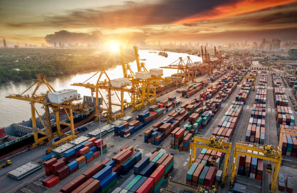 istock Logistics and transportation of Container Cargo ship and Cargo plane with working crane bridge in shipyard at sunrise, logistic import export and transport industry background 1083599268