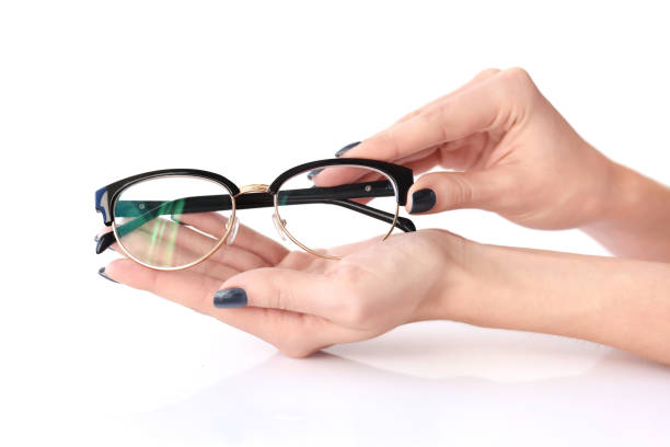 istock Female hands holding eye glasses on white background 1083608874