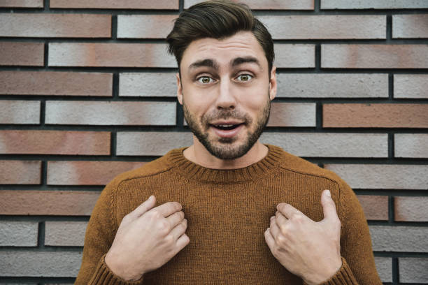 istock Closeup surprised man in eyeglasses looking at camera and open mouth on brick background. 1083609522