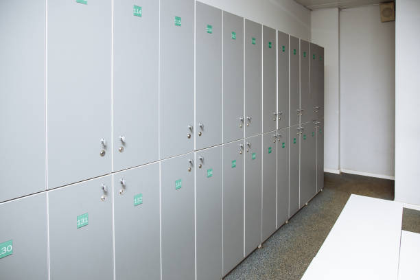 istock Row of steel lockers with white bench. 1083611562