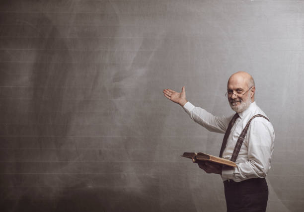 istock Smiling confident professor teaching and pointing at the blackboard 1083619794