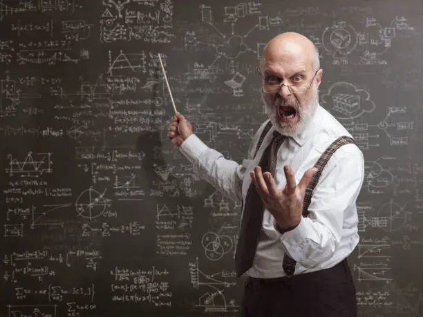 Senior authoritarian professor yelling and pointing at the blackboard with a stick: traditional education concept