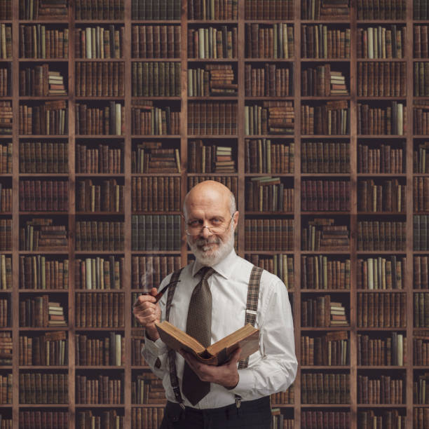 istock Academic professor in the library holding a book 1083619846