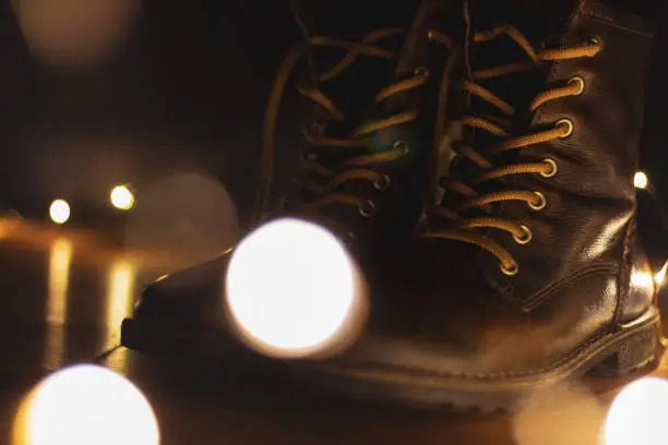 Photo of garland and brown leather shoes on a wooden floor